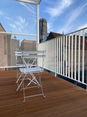 a white chair sitting on a deck on a balcony at #2800ourhome 201 in Mechelen