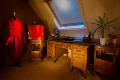 a room with a wooden desk and a window at B&B Oase in Londerzeel