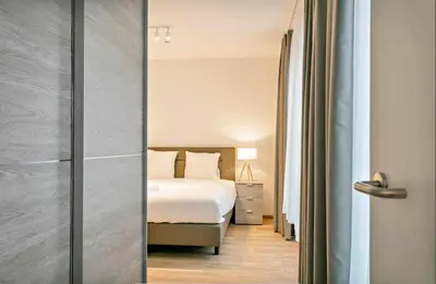a bedroom with a bed and a door with a mirror at Furnished 2 Bedroom Apartment in City Center in Brussels