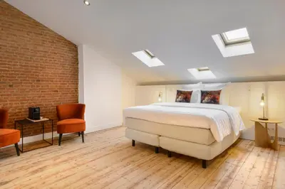 a bedroom with a bed and a brick wall at Our Bird's Nest in the Heart of Antwerp in Antwerp