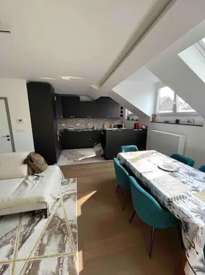 a living room with a table and blue chairs at Duplex avec terrasse quartier européen in Brussels