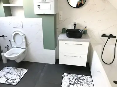 a white bathroom with a sink and a toilet at Duplex avec terrasse quartier européen in Brussels