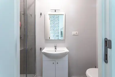 a white bathroom with a sink and a mirror at Room6 Van Lerius in Antwerp