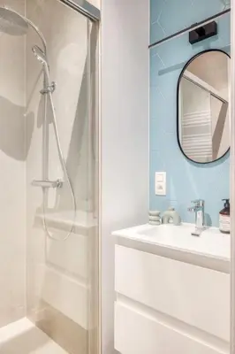 a bathroom with a shower and a sink and a mirror at 2-BR Haven in Antwerp in Antwerp
