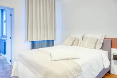 a white bed with white sheets and pillows at 2-BR Haven in Antwerp in Antwerp