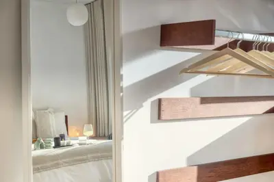a bedroom with white walls and a staircase with a bed at Magical renovated home in Antwerp in Antwerp
