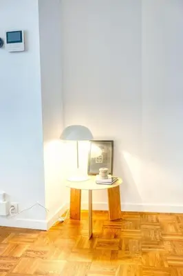 a table with a coffee cup and a lamp in a room at Magical renovated home in Antwerp in Antwerp