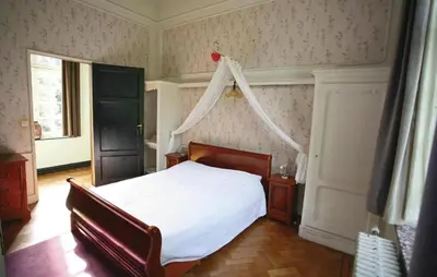 a bedroom with a bed with a white bedspread at Kasteel Ter Leyen in Assenede