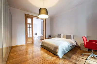 a bedroom with a bed and a red chair at Spacious apartment in Brussels, large private garden in Brussels
