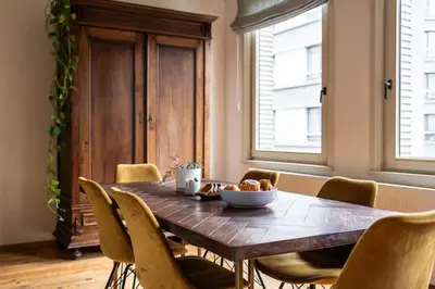 a dining room with a wooden table and chairs at Gezellig appartement op het hippe Zuid in Antwerp