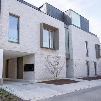 a large brick building with glass windows at Green HOME Wieze in Wieze