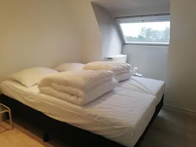 a bed with white sheets and pillows on it at Villa in Zottegem with Pool and Sauna in Wolvenhoek