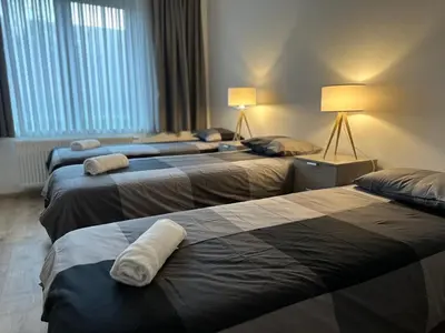 a hotel room with three beds with towels on them at Cosy 2 Bedroom Apartment in City Center in Brussels