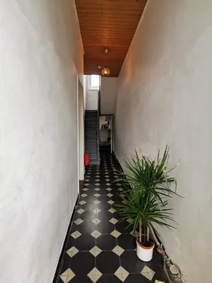 a hallway with a black and white checkered floor at Cozy city centre room with parkview in Ghent