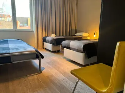a hotel room with two beds and a window at Luxurious Two Bedroom Apartment in Brussels
