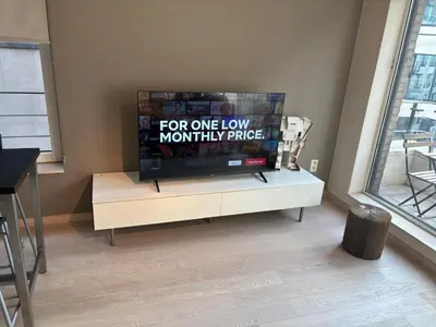 a flat screen tv sitting on top of a white cabinet at Luxurious Two Bedroom Apartment in Brussels