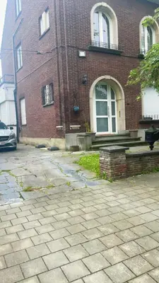 a brick building with a car parked in front of it at Apartment near atomium with parking in Vilvoorde