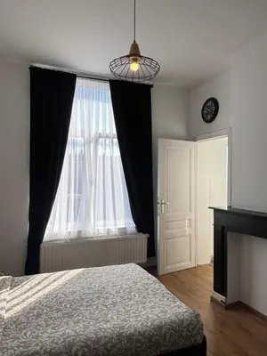 a bedroom with a bed and a large window at Studio Nahida in Brussels