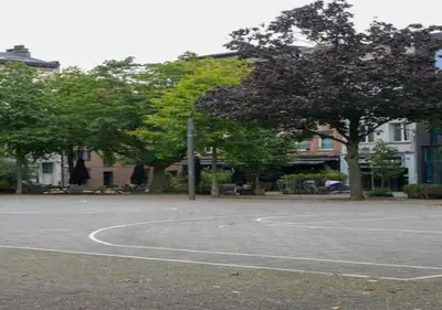 an empty basketball court with trees and buildings at Top Location - City Center 1BR with Stylish Decor in Antwerp