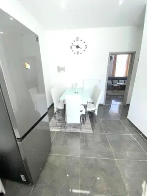 a room with a table and chairs and a clock on the wall at Appartement Bruxelles Belgique in Brussels
