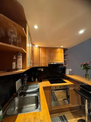 a kitchen with wooden cabinets and a sink at B&B appartement in Brussels