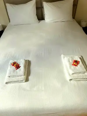 a bed with two towels with red flowers on it at Le Duplex-suite Joséphine in Brussels