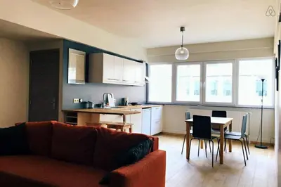 a living room and kitchen with a couch and a table at Fully equipped two bedroom apartment Schuman area in Brussels