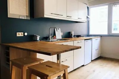a kitchen with white cabinets and a wooden counter top at Fully equipped two bedroom apartment Schuman area in Brussels