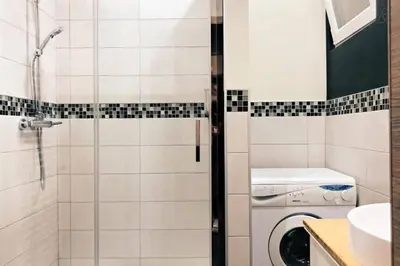a bathroom with a shower and a washing machine at Fully equipped two bedroom apartment Schuman area in Brussels