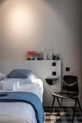 a bedroom with a bed and a black chair at Excellent Studio for Two in Central Ghent in Ghent