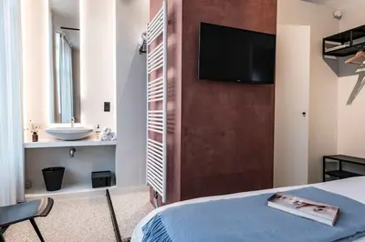 a bedroom with a bed and a bathroom with a sink at Cozy Studio for Two in Central Ghent in Ghent