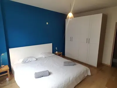 a bedroom with a white bed and a blue wall at Renovated one bedroom apartment Schuman area in Brussels