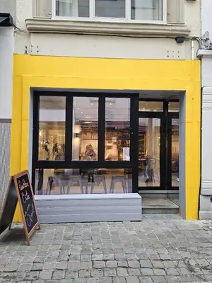 a yellow and black store window with chairs in it at Cozy Room in the Heart of Ghent I in Ghent