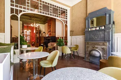 a restaurant with tables and chairs and a fireplace at Boutique Baron Osy Suite Second Street in Antwerp