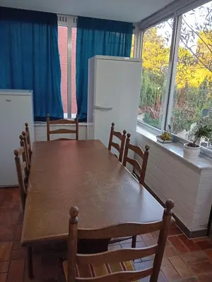 a kitchen with a wooden table and a refrigerator at Bloemetje in Asse