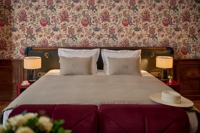 a bedroom with a bed with two tables and two lamps at Faubourg 21 in Brussels