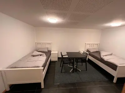 a room with two beds and a table in it at Bruxelles centre-ville in Brussels