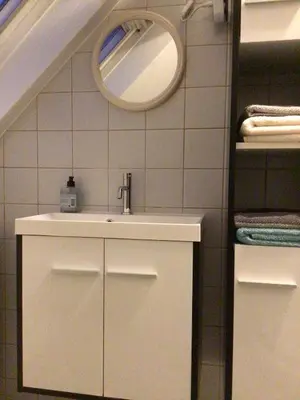 a bathroom with a sink and a mirror at Cosy attic apartment, terrace, 1 bedroom south, 1 double bed for 2, plus single bed if 3 guests in Opdorp