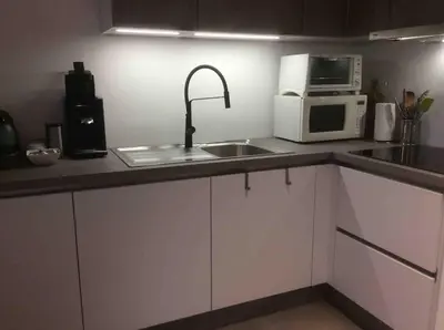 a kitchen with a sink and a microwave at Entire first floor, kitchen, bathroom, roofterrace, 1 bedroom if max 3 guests or 2 bedrooms if max 5 guests in Buggenhout