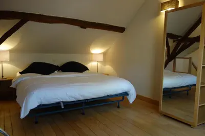 a bedroom with a large bed and a mirror at Geestmolenhof 1 in Holsbeek