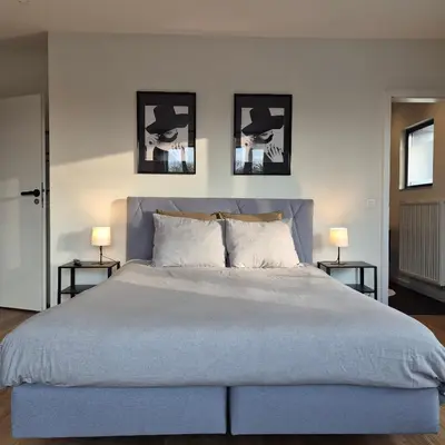 a bedroom with a large bed with three pictures on the wall at Orient Herent - Boetiekhotel in Herent