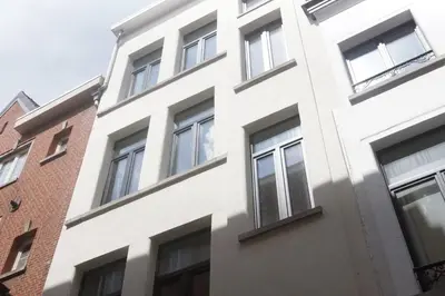 a white building with windows on the side of it at Stadsstudio Antwerpen in Antwerp