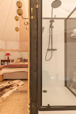 a bedroom with a tent with a bed and a glass door at Tipi Bo exclusief in Kaprijke