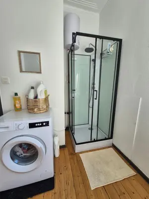a washing machine in a room with a shower at Souverain 94 in Brussels