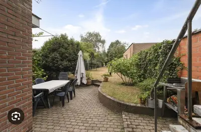 a patio with a table and chairs and an umbrella at Ngipe's Tomorrowland in Antwerp