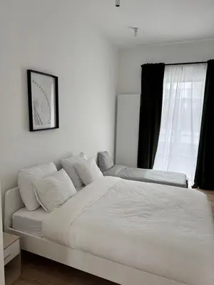 a white bed in a bedroom with a window at MIDI cozy apartment in Brussels