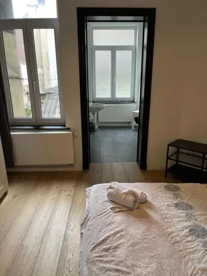 a bedroom with a bed with a pair of shoes on it at Flat south Brussels in Brussels
