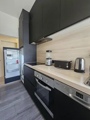 a kitchen with black cabinets and a counter top at L' Gante in Ghent
