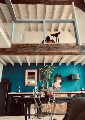 a dining room with a table and a blue wall at The Lofty Mystic's Lodge in Antwerp