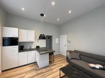 a living room with a couch and a kitchen at Midi Station 2 in Brussels